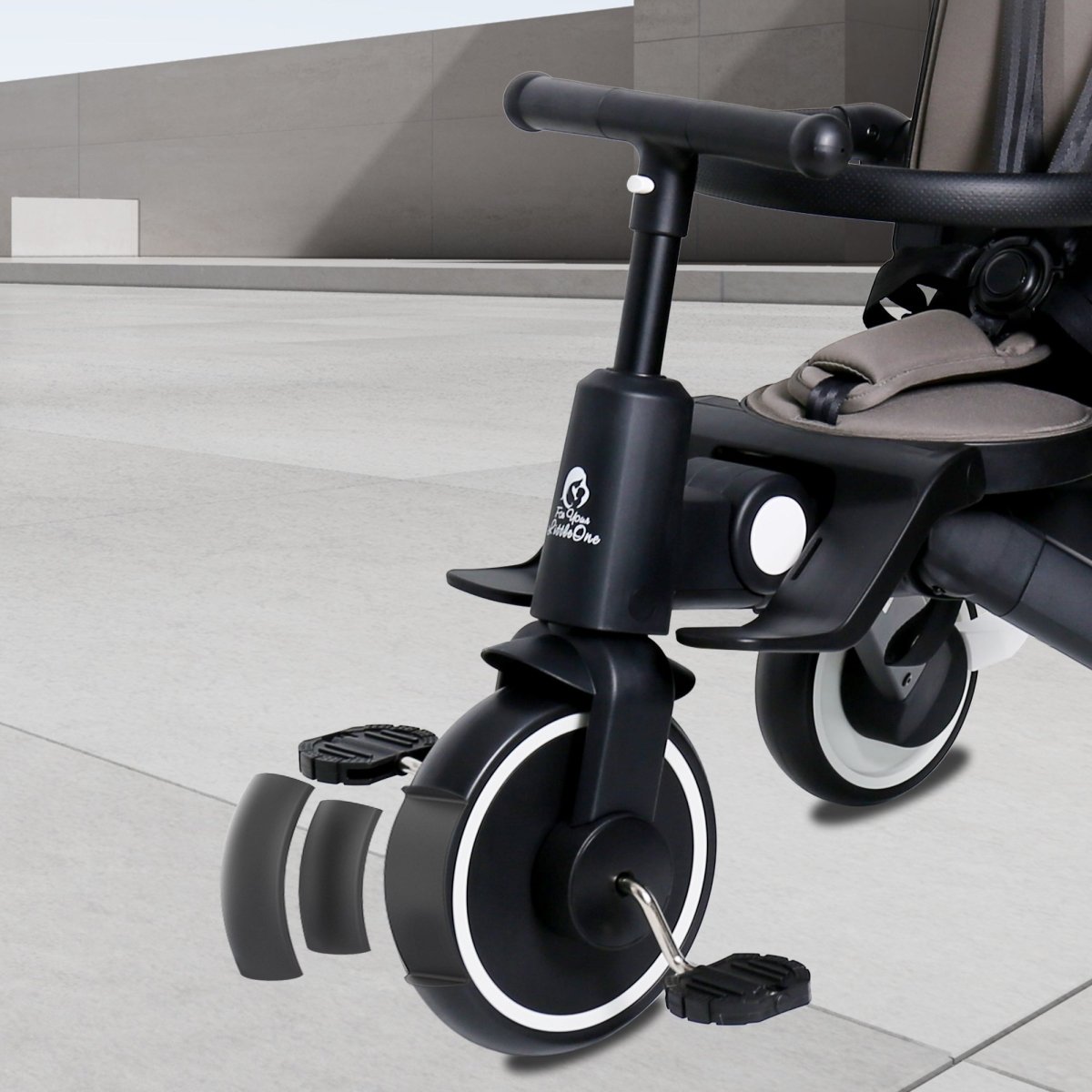 Jet black trike close-up of front wheel, footrest, and handlebar post