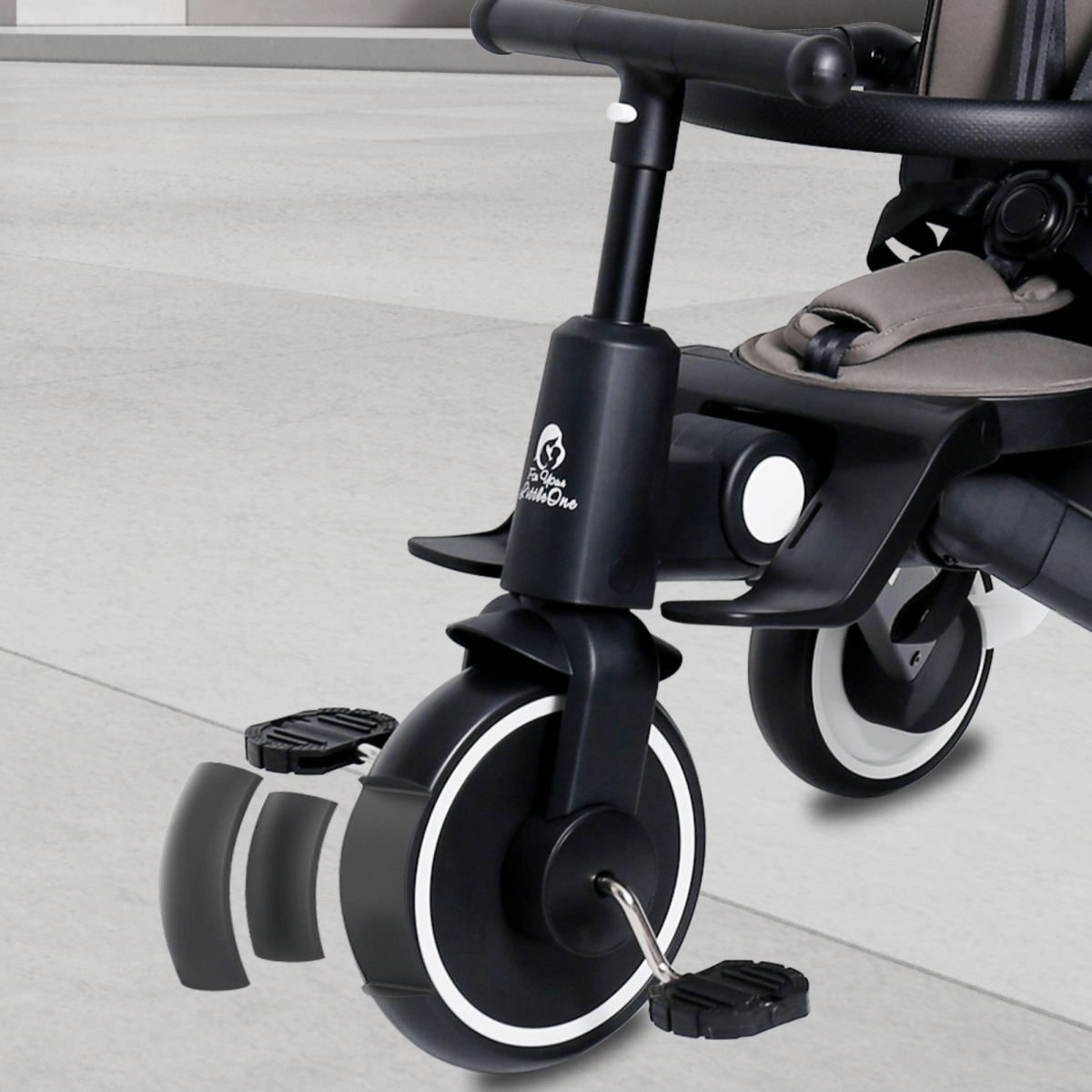 Close-up of folding trike wheels and handlebar, with attached seat and canopy