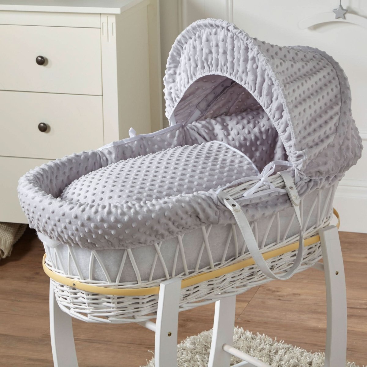 Grey Moses basket and stand with open hood and white wicker frame, padded mattress insert