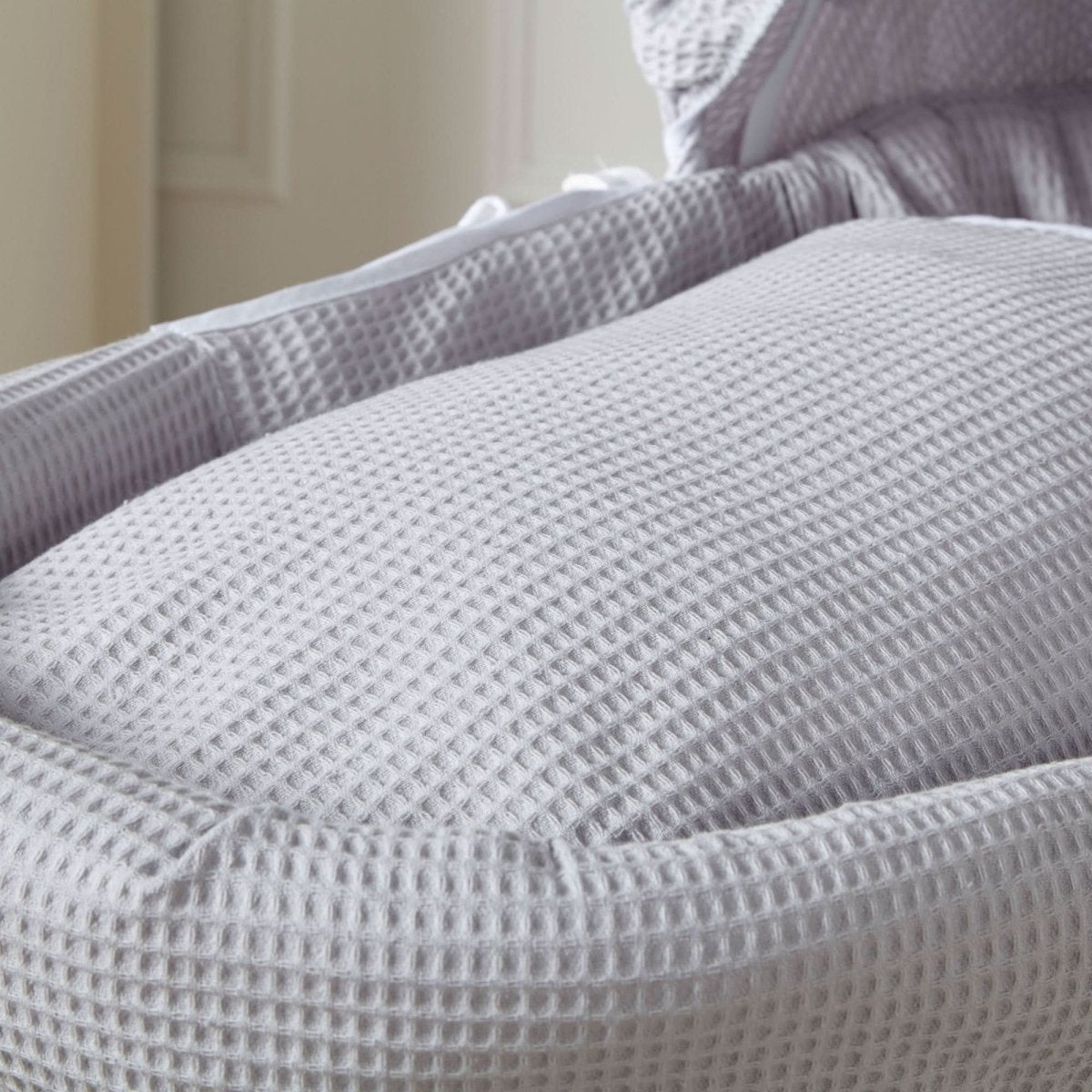 Grey waffle-texture Moses basket liner fabric with padded hood and cushion edge