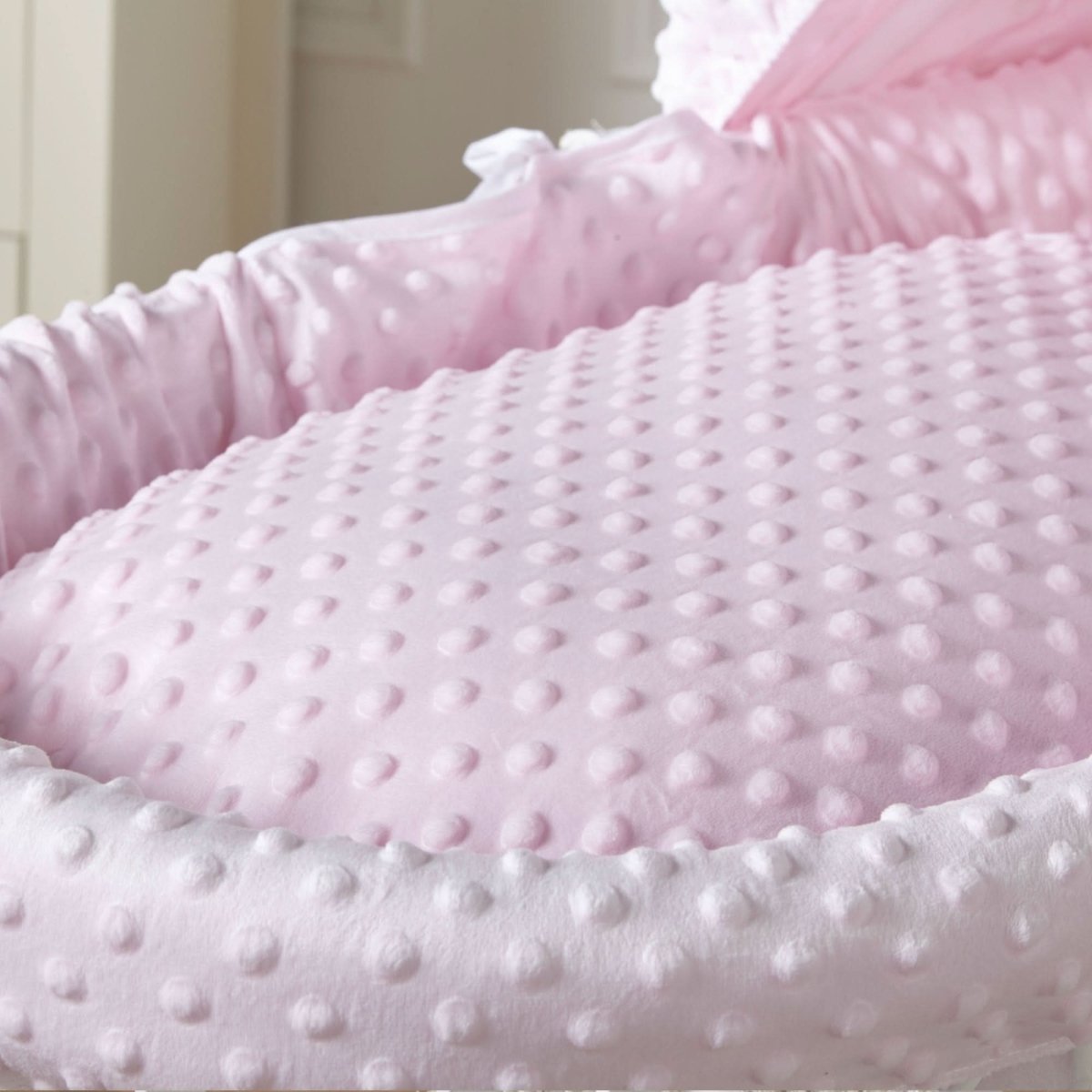 Close-up of pink dimple-textured bedding with raised dots