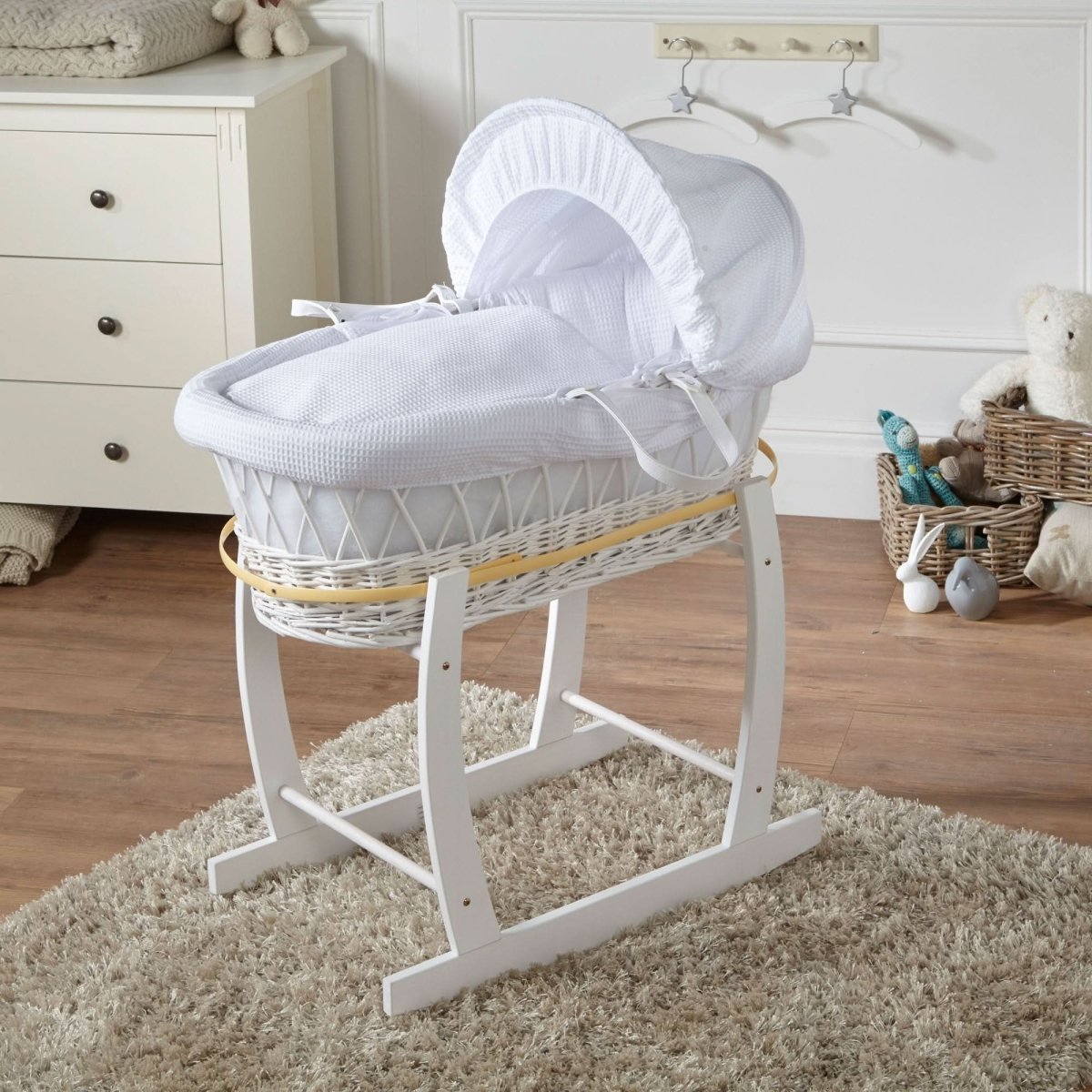 White wicker Moses basket with rocking stand and white padded hood