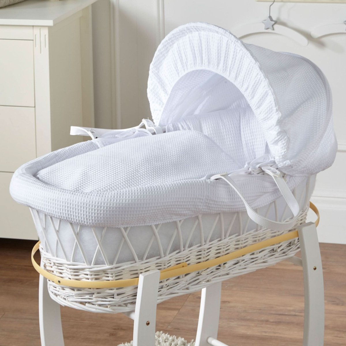 White wicker Moses basket with rocking stand and curved padded hood