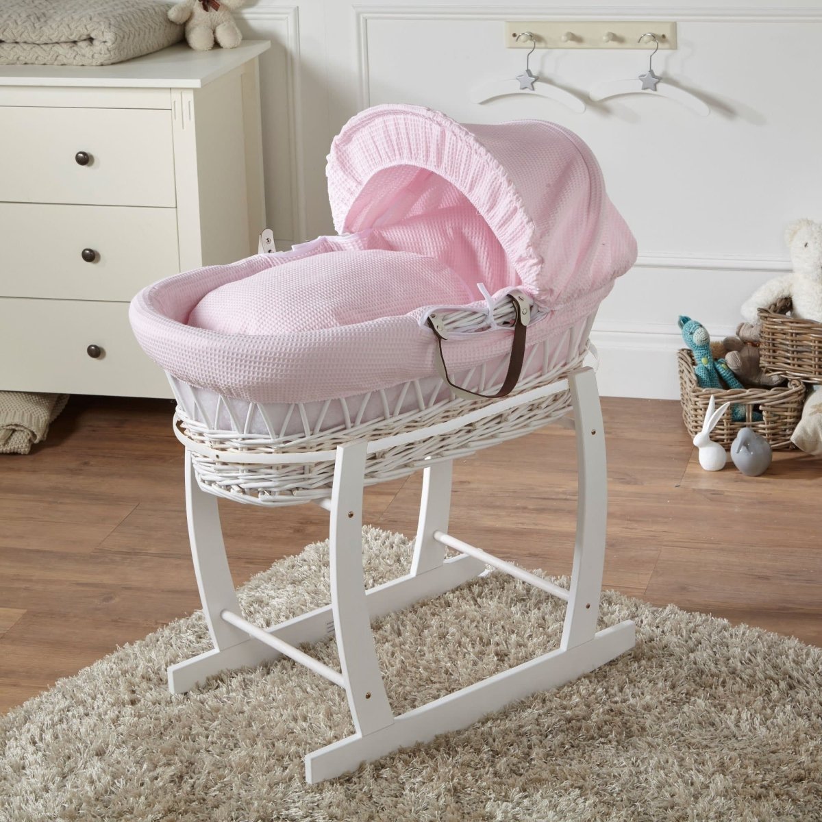 Wicker baby Moses basket with stand in white, pink bedding with canopy hood and ribbon ties