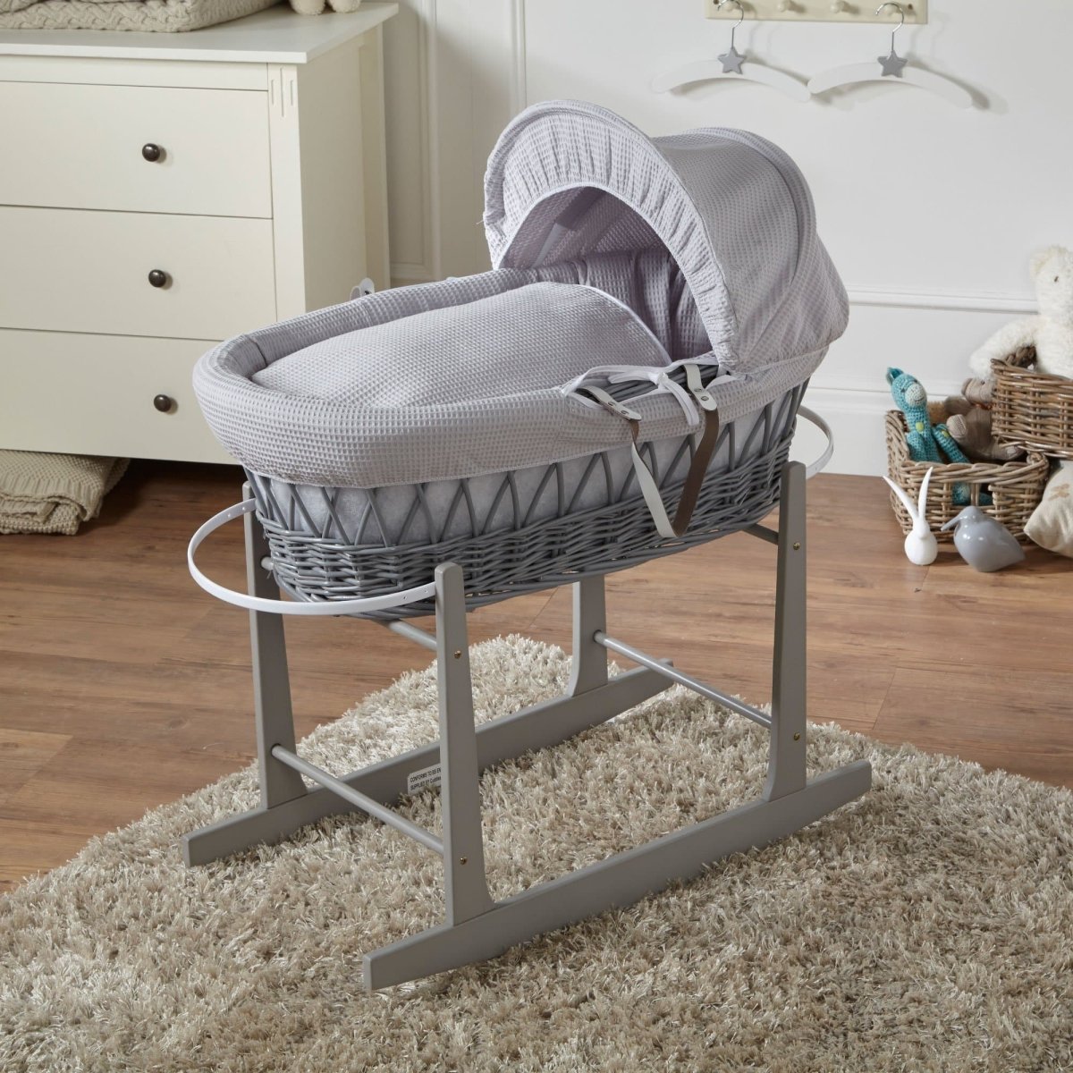 Light grey wicker Moses basket on stand with grey textured bedding and matching hood