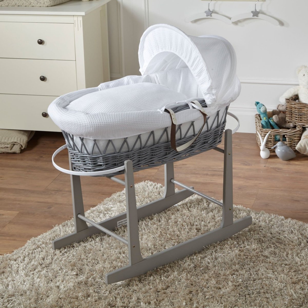 White wicker Moses basket on stand with white textured bedding and hood