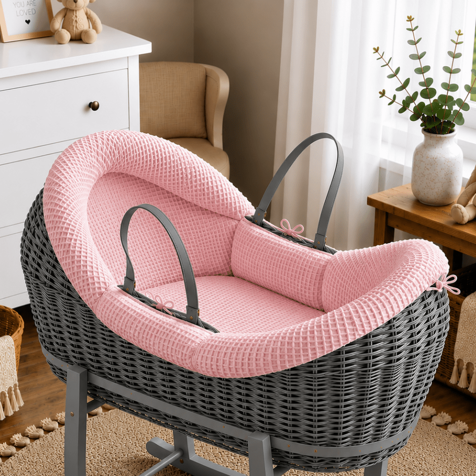 Pink wicker moses basket with pink padded waffle liner and carrying handles