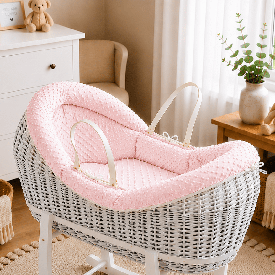 Wicker moses basket with pink textured carrycot insert and light-colored handle straps