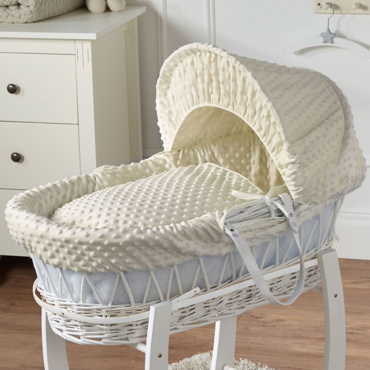 Cream wicker Moses basket with textured waffle bedding and padded adjustable hood