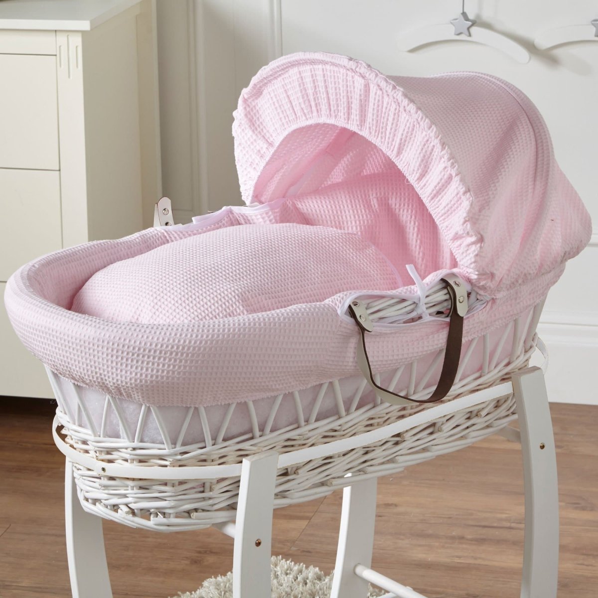 Wicker Moses basket with pink waffle bedding and white frame, no stand