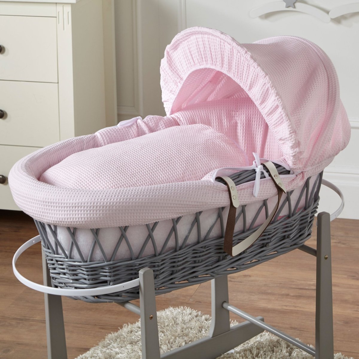 Wicker Moses basket with light pink quilted bedding and hood cover