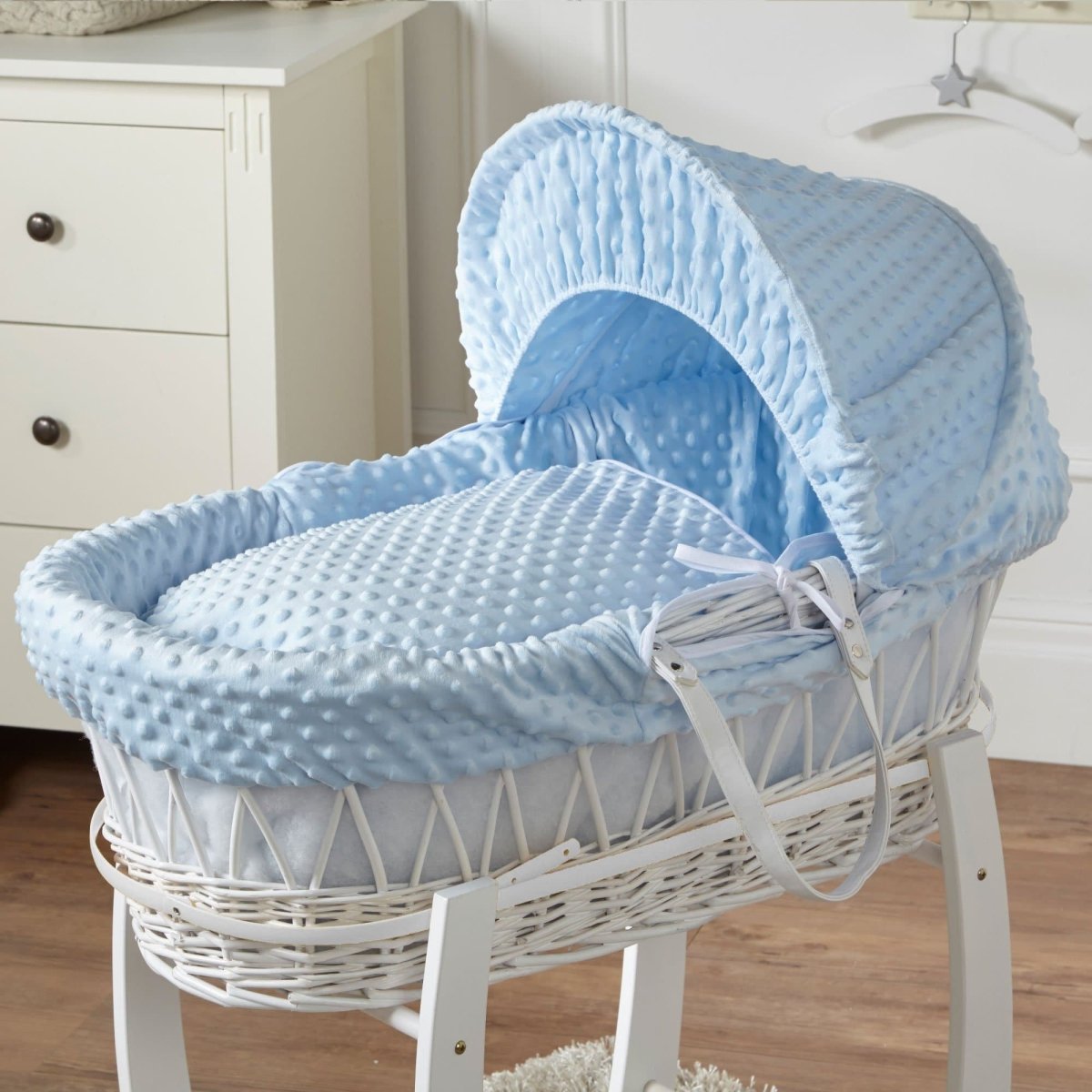Light blue wicker Moses basket with textured waffle bedding and padded adjustable hood