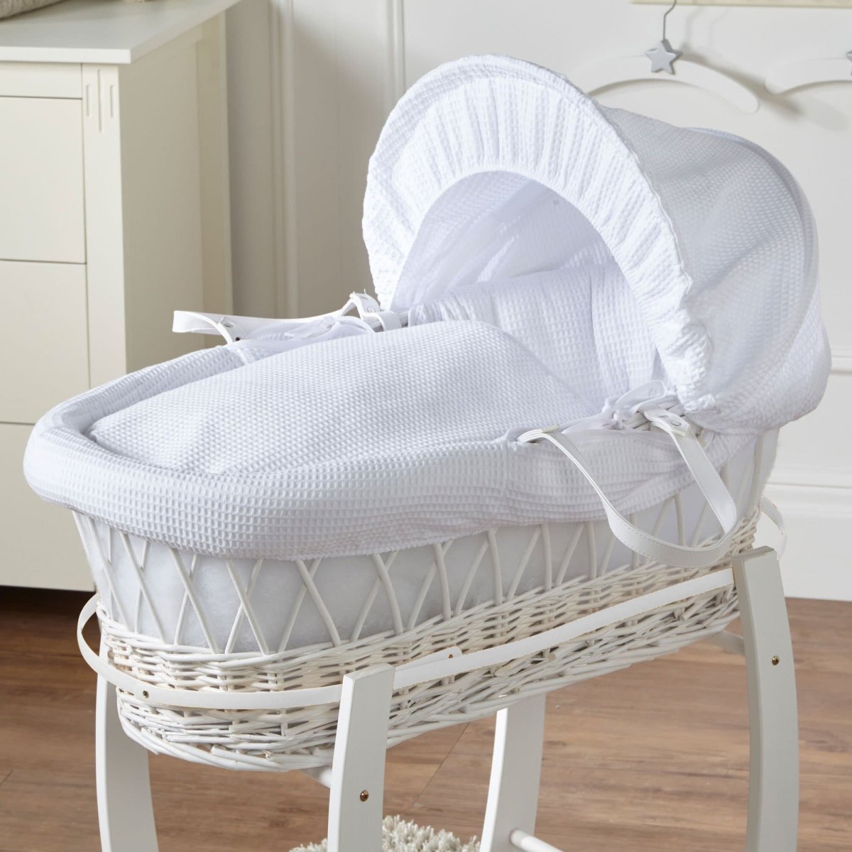 Wicker Moses basket with white waffle bedding and white frame, no stand